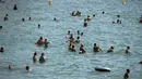 Para pengunjung menikmati hari yang panas di bawah sinar matahari pantai Bormes-les-Mimosas, Prancis, Selasa (11/8/2020). Cuaca panas diperkirakan akan berlangsung selama beberapa hari di seluruh negeri. (AP Photo/Daniel Cole)