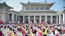 Para siswa ikut serta dalam 'pesta dansa' di luar Grand Theatre sebagai bagian dari acara yang menandai peringatan ke-68 berakhirnya Perang Korea atau disebut sebagai 'Hari Kemenangan dalam Perang Pembebasan Tanah Air Besar', di Pyongyang (27/7/2021). (AFP/STR/KCNA VIA KNS)