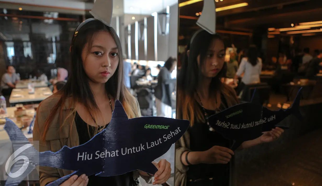 Aktivis Greenpeace Indonesia memperlihatkan replika hiu bertuliskan "Hiu Sehat untuk Laut Sehat" saat menggelar kampanye, Jakarta, Minggu (12/7/2015). Aksi tersebut sebagai upaya menyelamatkan hiu dari kepunahan. (Liputan6.com/Faizal Fanani)