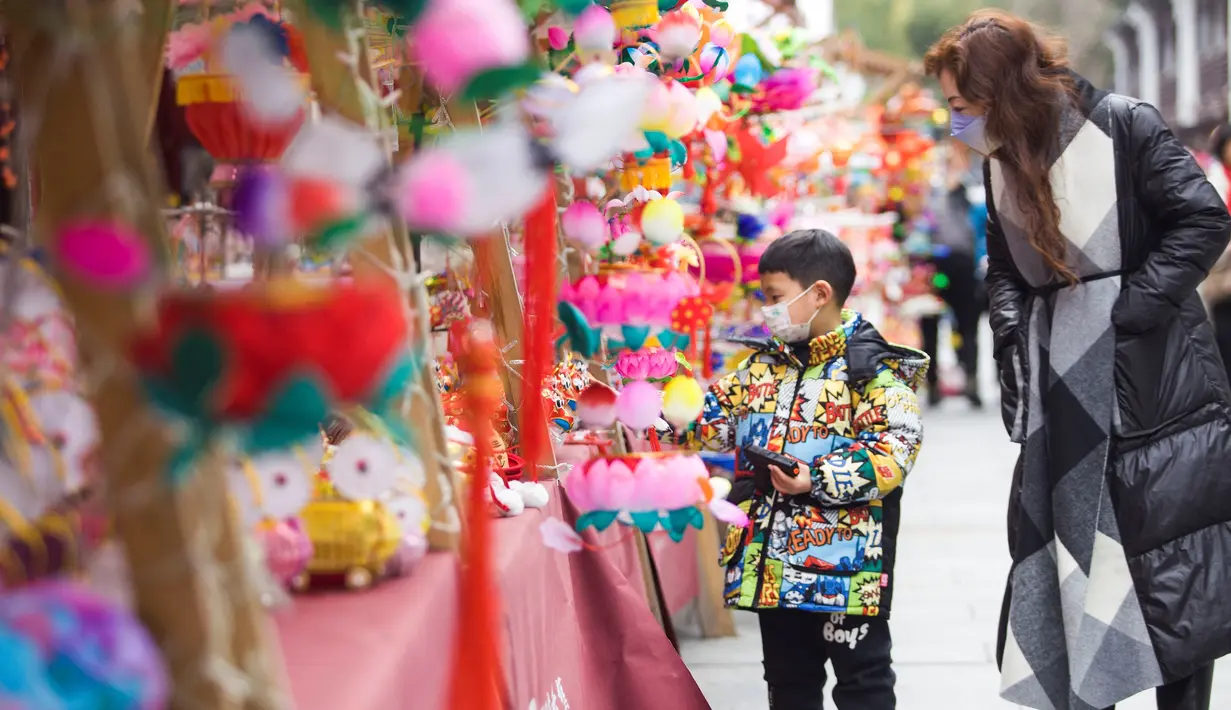 Orang-orang berbelanja lentera menjelang Festival Lampion, yang jatuh pada 15 Februari tahun ini - hari ke-15 Tahun Baru Imlek - di Nanjing di provinsi Jiangsu timur China pada 10 Februari 2022. Festival Lampion merupakan puncak sekaligus penutup dari perayaan Tahun Baru Imlek. (STR / AFP)