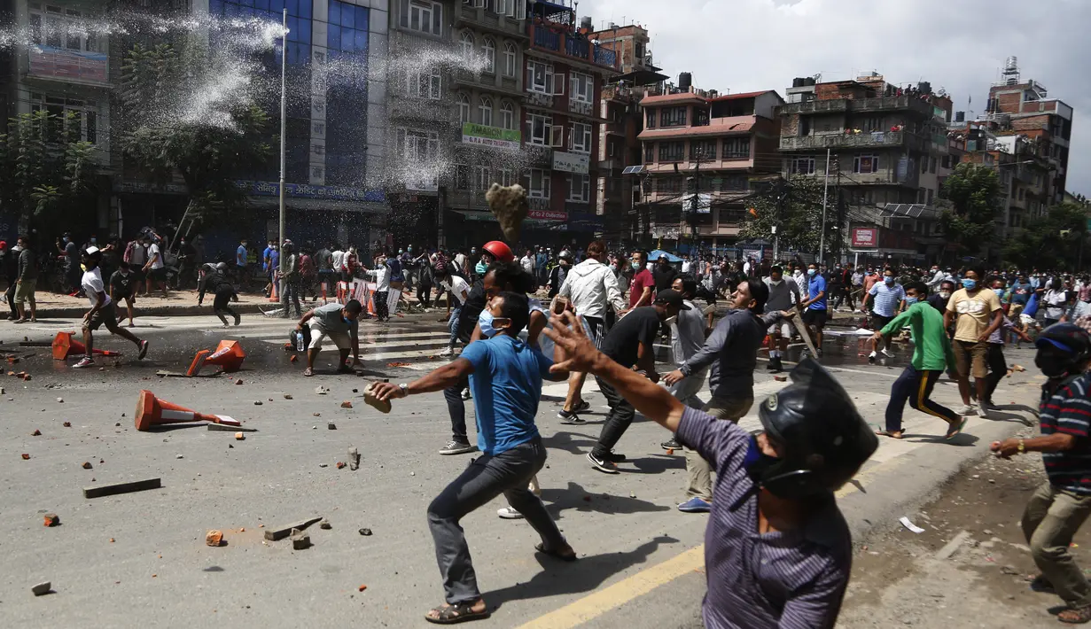 Warga melempari batu ketika kegiatan menarik kereta Dewa Rato Machhindranath dalam sebuah festival keagamaan dihentikan aparat kepolisian di Lalitpur, Nepal (3/9/2020). Aparat kepolisian berupaya membubarkan warga untuk mengendalikan penyebaran Covid-19. (AP Photo/Niranjan Shrestha)