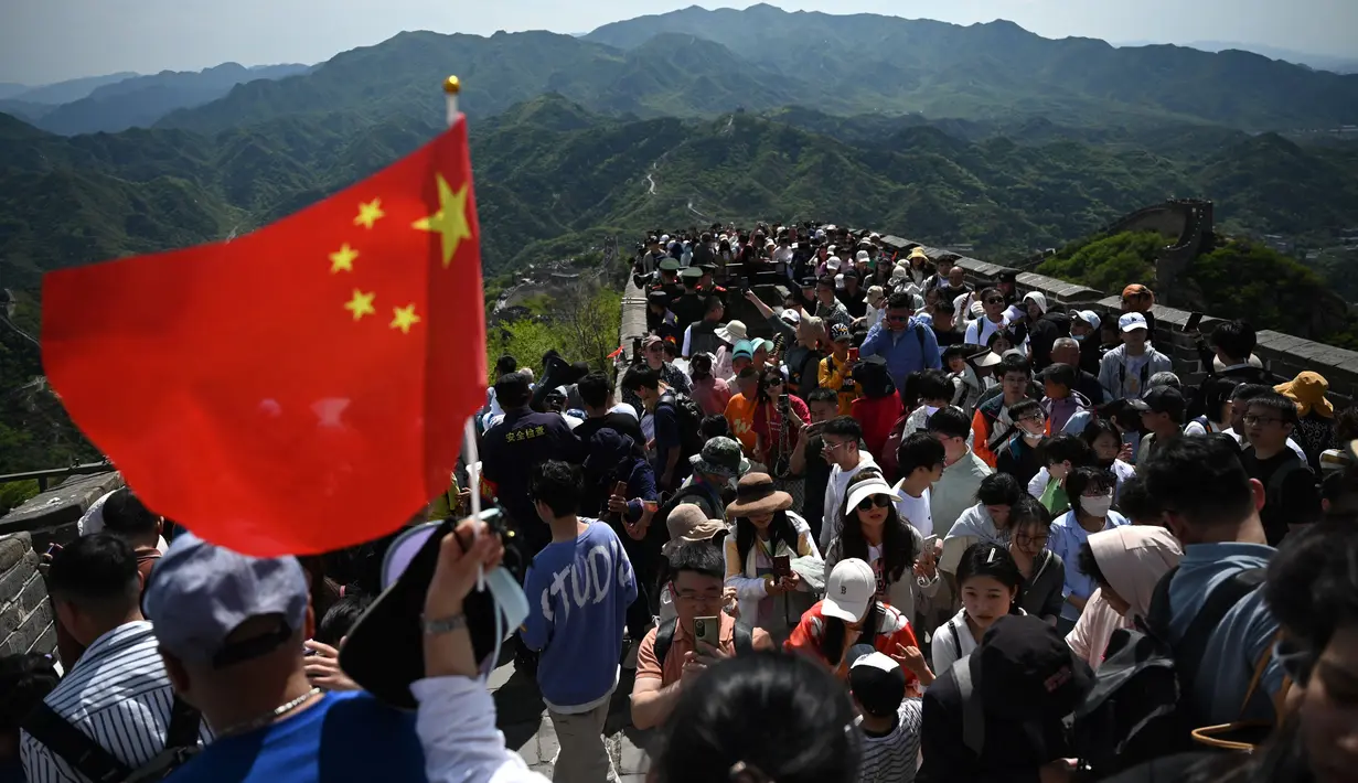 Orang-orang memanjat Tembok Besar China di Badaling, utara Beijing, hari pertama dari 5 hari libur nasional Hari Buruh atau May Day, Rabu (1/5/2024). (GREG BAKER / AFP)