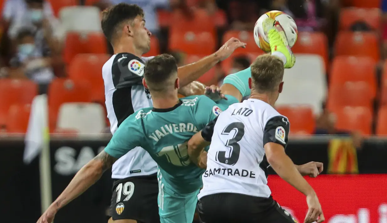 Gelandang Real Madrid, Federico Valverde berebut bola dengan pemain Valencia, Toni Lato (kanan) dan Hugo Duro pada lanjutan La Liga di Stadion Mestalla, Senin (20/9/2021) dini hari WIB. Real Madrid menang 2-1 secara dramatis atas Valencia. (AP Photo/Alberto Saiz)