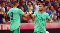 Selebrasi Eden Hazard bersama Karim Benzema setelah menjebol gawang Real Bull Salzburg dalam laga persahabatan di Austria (7/8/2019). (APA/AFP/Krugfoto)