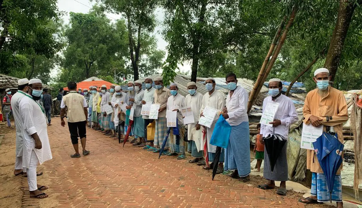 Pengungsi Rohingya menunggu untuk divaksinasi COVID-19 di Cox's Bazar, Bangladesh (10/8/2021).  Pemerintah Bangladesh dan lembaga bantuan mulai memvaksinasi pengungsi Rohingya pada Selasa ketika gelombang virus meningkatkan risiko kesehatan di kamp-kamp pengungsian. (AP Photo/ Shafiqur Rahman)