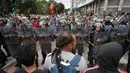 Massa berhadapan dengan polisi anti huru hara saat memprotes kenaikan tarif bus di Sao Paulo, Brasil, Selasa (12/1). Mereka protes karena di tengah krisis ekonomi, tarif transportasi angkutan bus justru naik. (AFP PHOTO/NELSON Almeida)