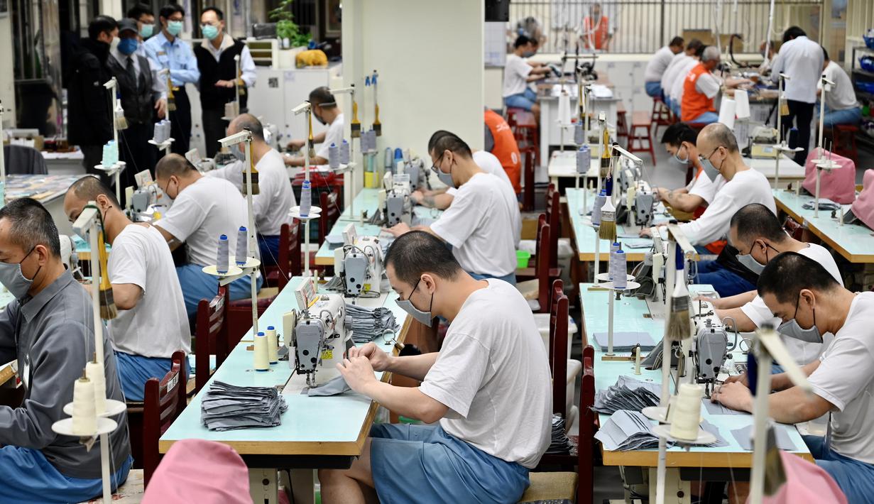 Para tahanan menggunakan mesin jahit saat membuat masker di Penjara Taipei di Kota Taoyuan, Taiwan utara (10/3/2020). Lebih dari 4.000 orang telah meninggal dan lebih dari 110.000 telah terinfeksi virus corona di seluruh dunia. (AFP/Sam Yeh)