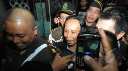 Ekpresi Mandra saat keluar dari gedung Kejaksaan Agung menuju mobil tahanan yang telah menjemputnya, Jakarta, Jumat (6/3/2015). Mandra ditahan karena diduga terlibat kasus penggelembungan dana di TVRI tahun 2012. (Liputan6.com/Herman Zakharia)
