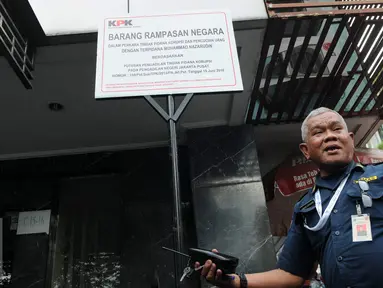 Seorang petugas berdiri di depan plang segel sebuah rumah toko (ruko) yang berada di Wijaya Grand Center, Jakarta Selatan, Senin (28/11). Ruko tersebut masuk dalam daftar kekayaan Nazaruddin yang dirampas negara. (Liputan6.com/Helmi Affandi)