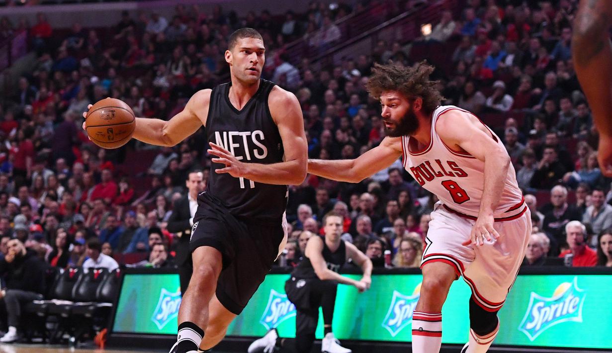 Pemain Nets, Brook Lopez (11) berusaha melewati hadangan saudara kembarnya pemain Chicago Bulls, Robin Lopez (8) pada lanjutan NBA basketball game, (28/12/2016) di United Center.  Bulls menang 101-99. (Reuters/Mike DiNovo-USA TODAY Sports)