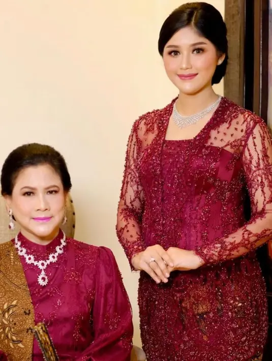 Erina pun tampil senada dengan ibu mertua. Iriana mengenakan kebaya lengan panjang puff berkerah tinggi berpayet dipadukan selendang coklat batik. Iriana pin mengenakan perhiasan kalung dan anting silver dengan batu merahnya. [@erinagudono]