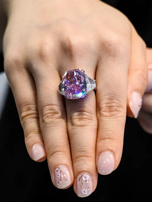 Seorang perempuan memamerkan berlian Sakura 15,81 karat selama pratinjau pra-lelang Christies di Hong Kong pada 20 Mei 2021. Sakura dijual di rumah lelang Christie's dan menjadi berlian terbesar dalam sejarah pelelangan di sana. (Anthony WALLACE/AFP)