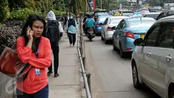 Sejumlah pejalan kaki melintas di trotoar kawasan Sudirman, Jakarta, Selasa (2/2/2016). Gubernur Ahok berencana akan membuat trotoar yang ramah kepada para penyandang disabilitas. (Liputan6.com/Faizal Fanani)