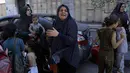 Warga Palestina dan beberapa anak-anak bergegas ke jalan menyusul serangan udara Israel di Kota Gaza, Jalur Gaza tengah, Minggu, 15 Oktober 2023. (AP Photo/Abed Khaled)
