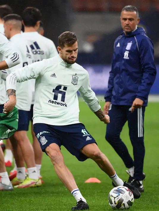 Pemain Spanyol Inigo Martinez (kiri) menendang bola saat pelatih Luis Enrique melihat sesi latihan jelang pertandingan semifinal UEFA Nations League melawan Italia di Stadion San Siro, Milan, Italia, 5 Oktober 2021. Spanyol akan menghadapi Italia pada semifinal UEFA Nations League. (FRANCK FIFE/AFP)