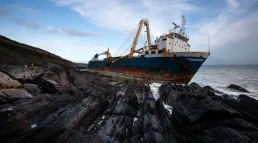Kapal kargo sepanjang 77 meter, MV Alta,  terjebak di atas batu di dekat Ballycotton, Cork, Irlandia, Selasa (18/2/2020). "Kapal hantu" yang berlayar tanpa awak selama lebih dari satu tahun hanyut dan terbawa ke pantai selatan Irlandia menyusul sapuan Badai Dennis. (Cathal Noonan/AFP)