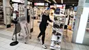 Seorang perempuan meletakkan rak sepatu di luar toko di Aalborg Storcenter di Aalborg, Denmark saat pertokoan dibuka kembali, pada Rabu (21/4/2021). Denmark membuka kembali berbagai aktivitas ekonomi negaranya setelah kasus infeksi Covid-19 mengalami penurunan. (Henning Bagger/Ritzau Scanpix via AP)