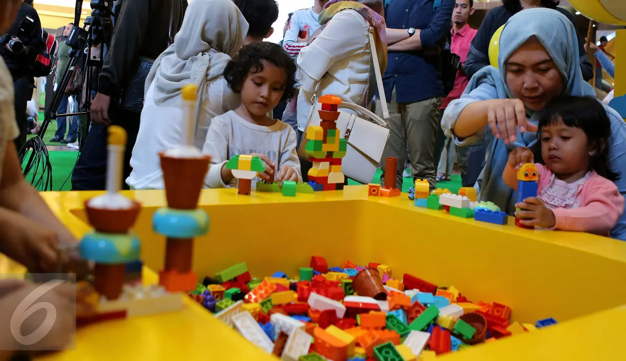 Seorang anak didampingi orang tua menyusuk balok di Kota Kasablanka, Jakarta (12/11). Area ini dipenuhi dengan berbagai permainan interaktif yang dapat dinikmati seluruh anggota keluarga. (Liputan6.com/Fery Pradolo)