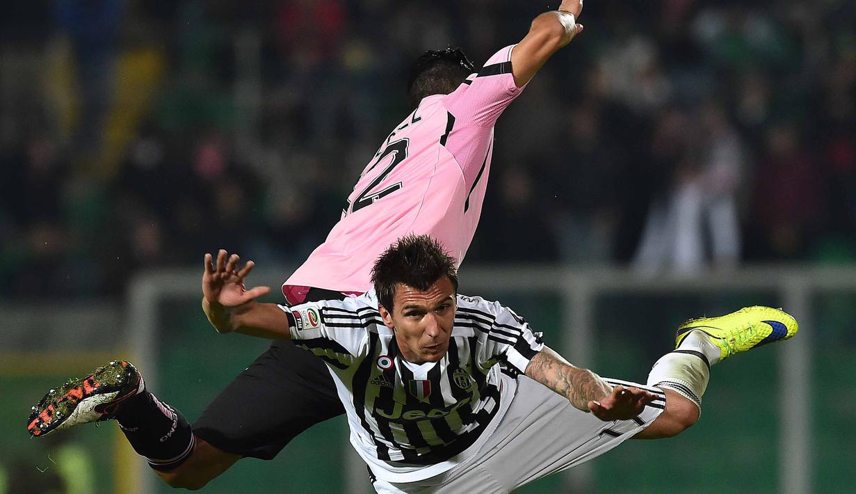 Pemain Juventus, Mario Mandzukic (kanan) berduel udara dengan pemain Palermo pada lanjutan Liga Italia Serie A  di Stadion Renzo Barbera, Palermo, Senin (30/11/2015) dini hari WIB .  (AFP Photo/Gabriel Bouys)