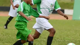 Siswa SDN Conggeang 1 Sumedang menggiring bola pada babak final MILO Football Championship Bandung melawan SDN Cimahi Mandiri 1 di Stadion Siliwangi, Bandung Minggu (15/4). SDN Conggeang 1 unggul dengan skor 1-0. (Liputan6.com/Pool/Rizky)