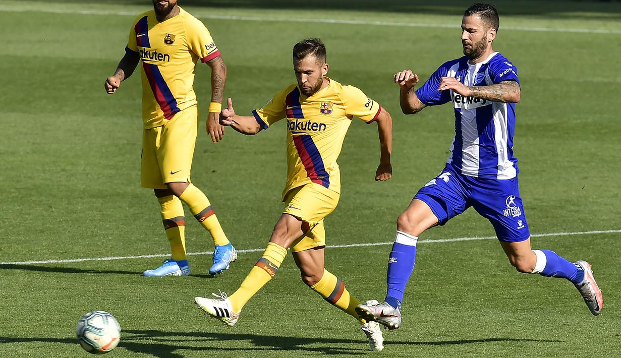 Pemain Barcelona, Jordi Alba, berebut bola dengan pemain Alaves, Luis Rioja, pada laga La Liga di Stadion Mendizorroza, Minggu (19/7/2020). Barcelona menang dengan skor 5-0. (AP/Alvaro Barrientos)