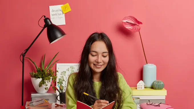 Seorang perempuan sedang mencatat di buku catatannya (Foto Dok: Freepik/freepik)