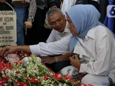 Kerabat dan saudara menabur bunga di makam Donny Kesuma di TPU Tanah Kusir, Jakarta, Rabu (20/3/2024). (Liputan6.com/Herman Zakharia)