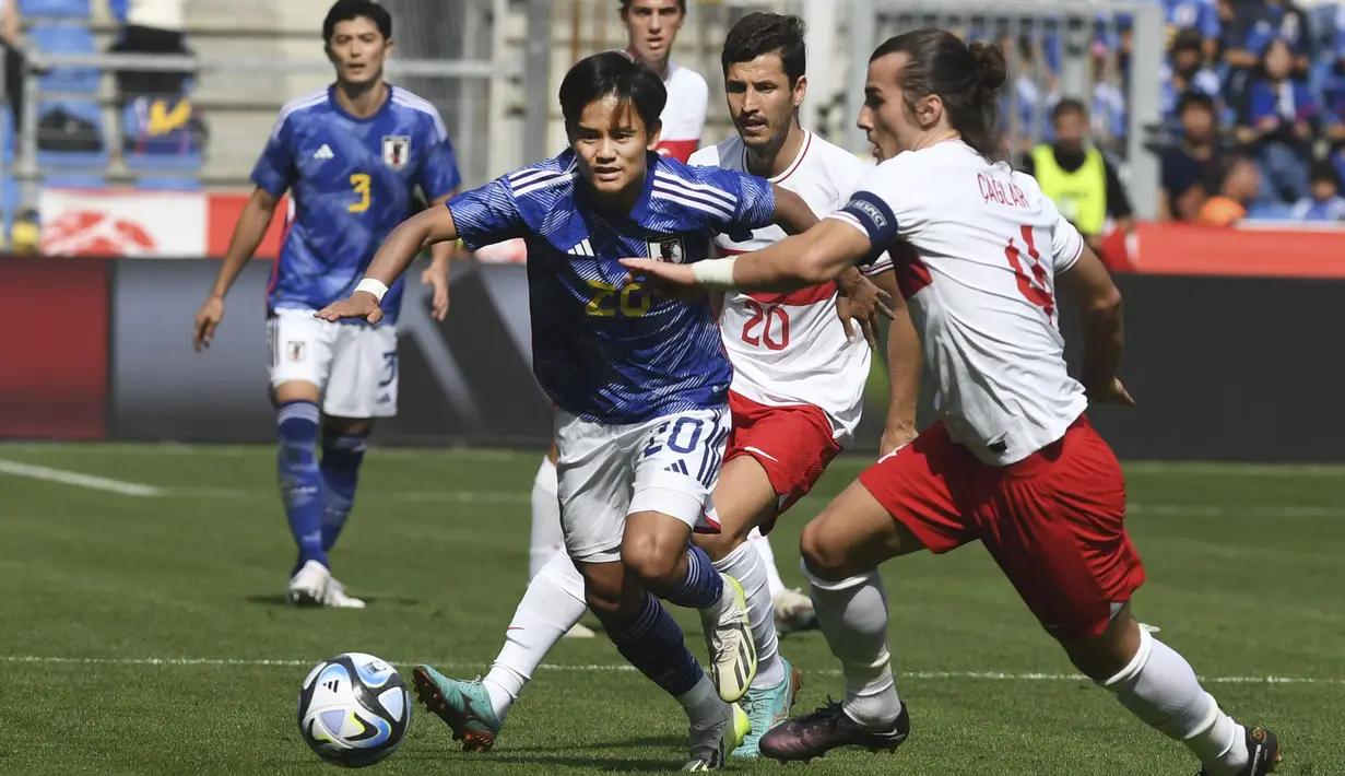 Gelandang Timnas Jepang, Takefusa Kubo (tengah) menguasai bola dibayangi bek Timnas Turki, Caglar Soyuncu pada laga persahabatan FIFA Matchday di Luminus Arena, Genk, Belgia, Selasa (12/9/2023) malam WIB. (AP Photo/Frederic Sierakowski)