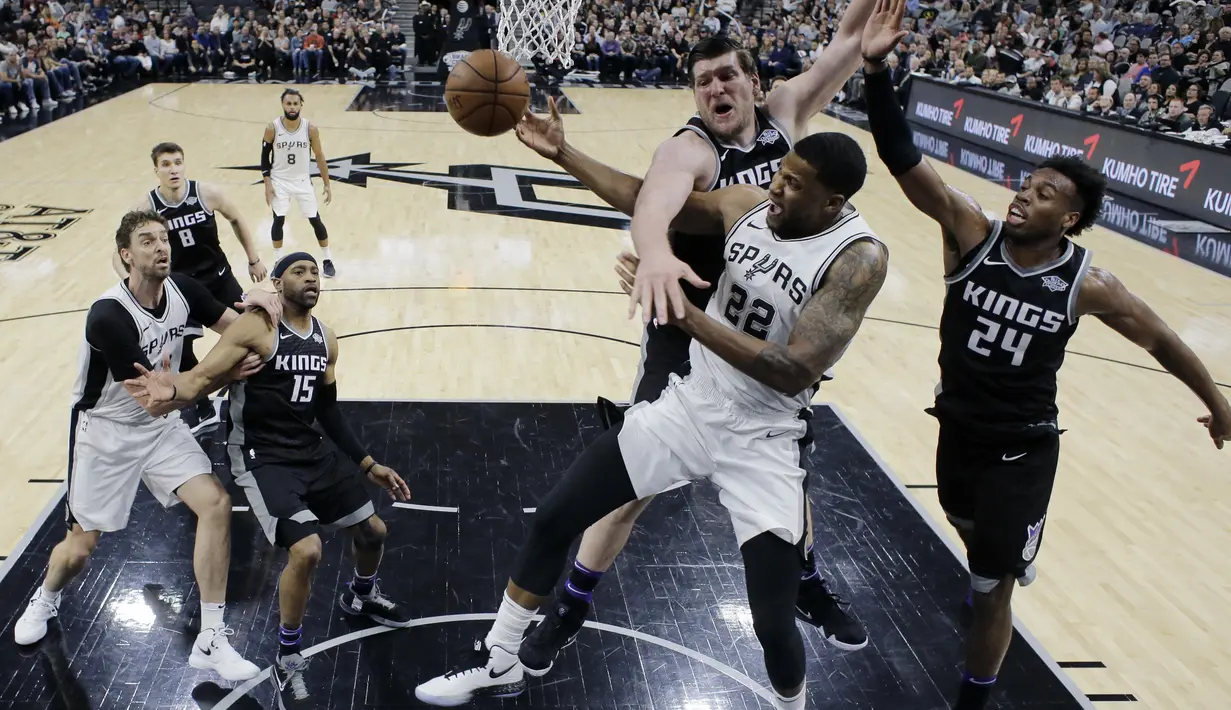 Aksi pemain San Antonio Spurs, Rudy Gay (22) melewati adangan dua pemain Sacramento Kings pada laga NBA basketball game di A&T Center, San Antonio, (9/4/2018). Spurs menang 98-85. (AP/Eric Gay)