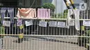 Handuk serta pakaian pencari suaka digantung bersama poster tuntutan di pagar kantor UNHCR, Jalan Kebon Sirih, Jakarta, Sabtu (1/5/2021). Para pencari suaka menuntut Komisi Tinggi PBB untuk Pengungsi (UNHCR) meminta kejelasan atas status dan memperhatikan nasib mereka. (Liputan6.com/Herman Zakharia)