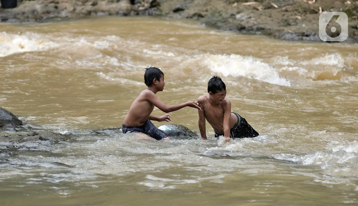 Anak-anak berenang di Kali Ciliwung, Depok, Jawa Barat, Minggu (27/6/2021). Keterbatasan lahan bermain di tengah masa pandemi COVID-19 membuat anak-anak memilih untuk berenang di Kali Ciliwung sebagai wahana alternatif saat libur sekolah. (merdeka.com/Iqbal S. Nugroho)