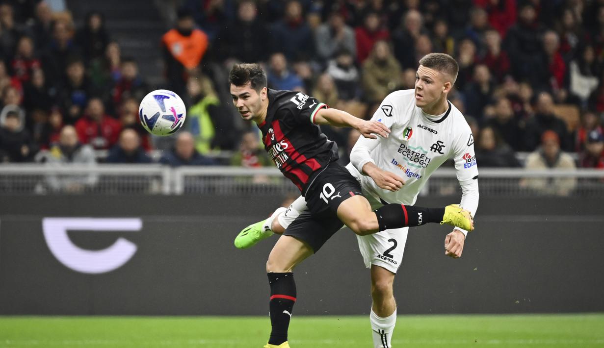 Gelandang AC Milan, Brahim Diaz  dan pemain Spezia Emil Holm berebut bola selama pertandingan lanjutan Liga Serie A Italia di stadion San Siro, di Milan, Italia, Minggu (6/11/2022). Kemenengan ini membuat AC Milan terus menempel Napoli dengan 29 poin di posisi kedua klasemen Serie A, berjarak enam poin. (AP Photo /Antonio Calanni)