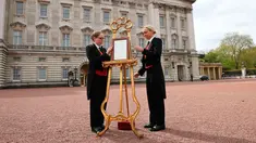 Senior footman Olivia Smith dan footman Heather McDonald saat memajang pengumuman kelahiran bayi baru kerajaan di halaman depan Istana Buckingham, London, Inggris, Senin (23/4). Kate Middleton melahirkan anak ketiganya. (Pool Photo via AP)
