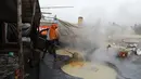 Seorang pekerja mengaduk jus tebu untuk membuat gula merah di pinggiran Bareilly, India, Selasa (23/3/2021).  Jaggery adalah gula tradisional yang tidak dimurnikan yang dikonsumsi di banyak bagian Asia, terbuat dari molase tebu dan nira kurma. (AP Photo/Rajesh Kumar Singh)