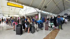 Wisatawan antre memasuki terminal keberangkatan Bandara Lombok Praya di pulau Lombok, NTB, Senin (6/8). BNPB melaporkan Bandara Lombok Praya pada pagi ini menjalani aktivitas seperti biasa setelah gempa dahsyat berkekuatan 7,0 SR. (AFP/Adek BERRY)
