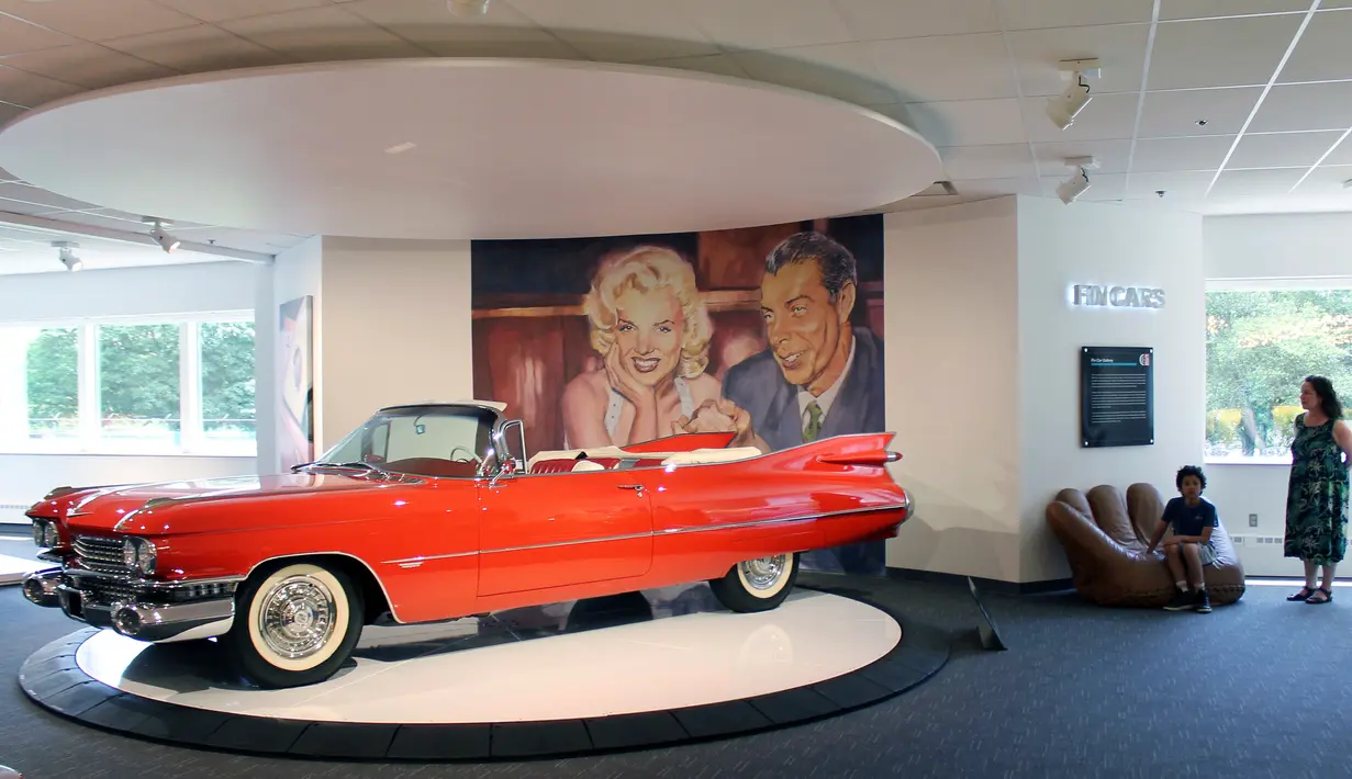 Pengunjung beristirahat di samping mobil Cadillac Series 62 tahun 1959 yang dipajang di Newport Car Museum di Portsmouth (13/6). (AP Photo / Michelle R. Smith)