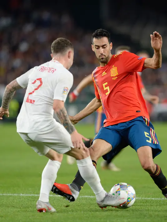 Gelandang Inggris, Kieran Trippier berusaha melewati bek Spanyol, Sergio Busquets selama pertandingan UEFA Nations League 2018 di stadion Benito Villamarin, Sevilla (15/10). Inggris menang 3-2 atas Spanyol. (AFP Photo/Cristina Quicler)