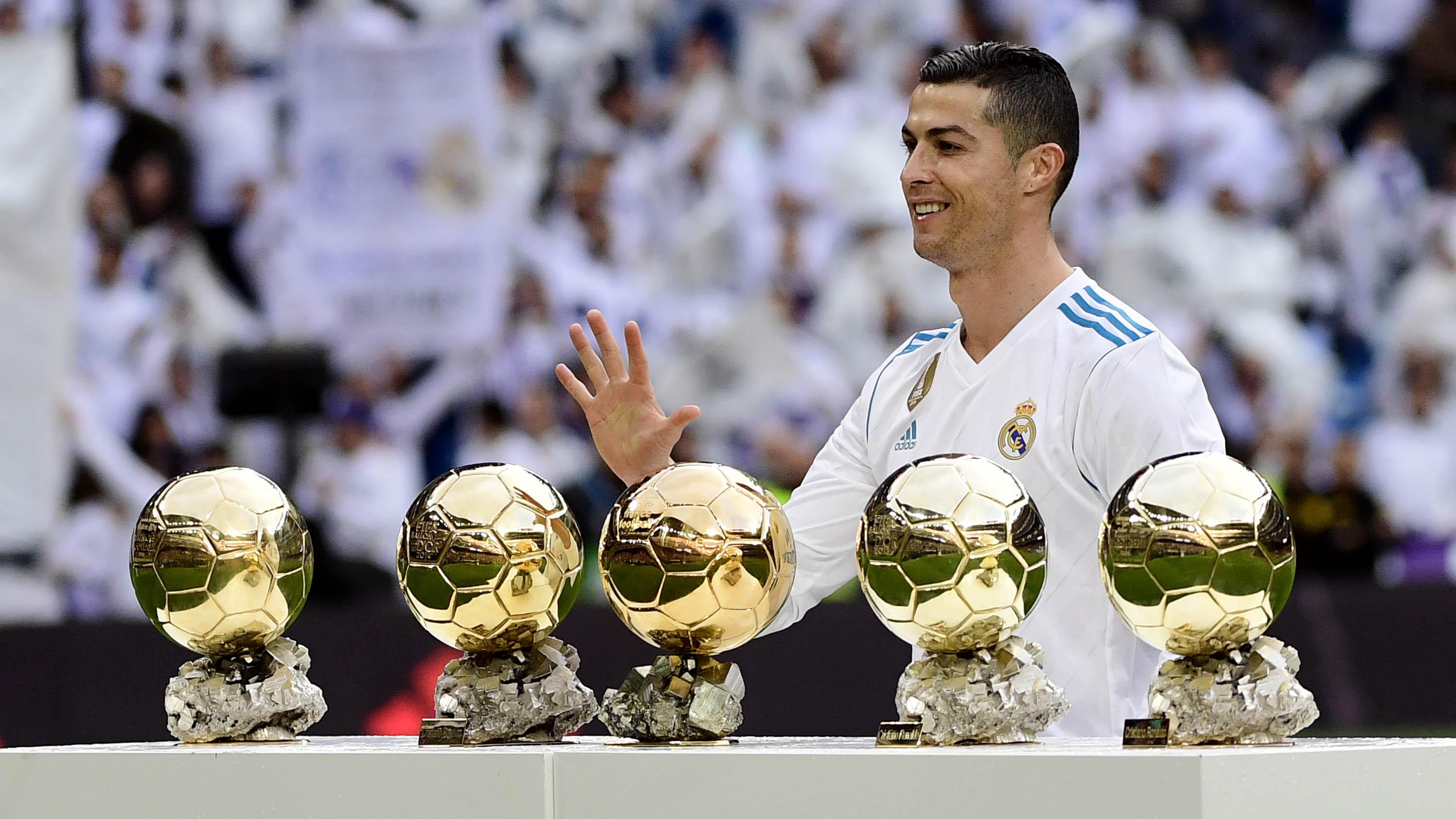 Bintang Real Madrid, Cristiano Ronaldo, berpose dengan kelima trofi Ballon d'Or di Stadion Santiago Bernabeu, Sabtu (9/12/2017). Cristiano Ronaldo meraih Ballon d'Or 2017 setelah unggul dari Lionel Messi dan Neymar. (AFP/Pierre-Philippe Marcou)