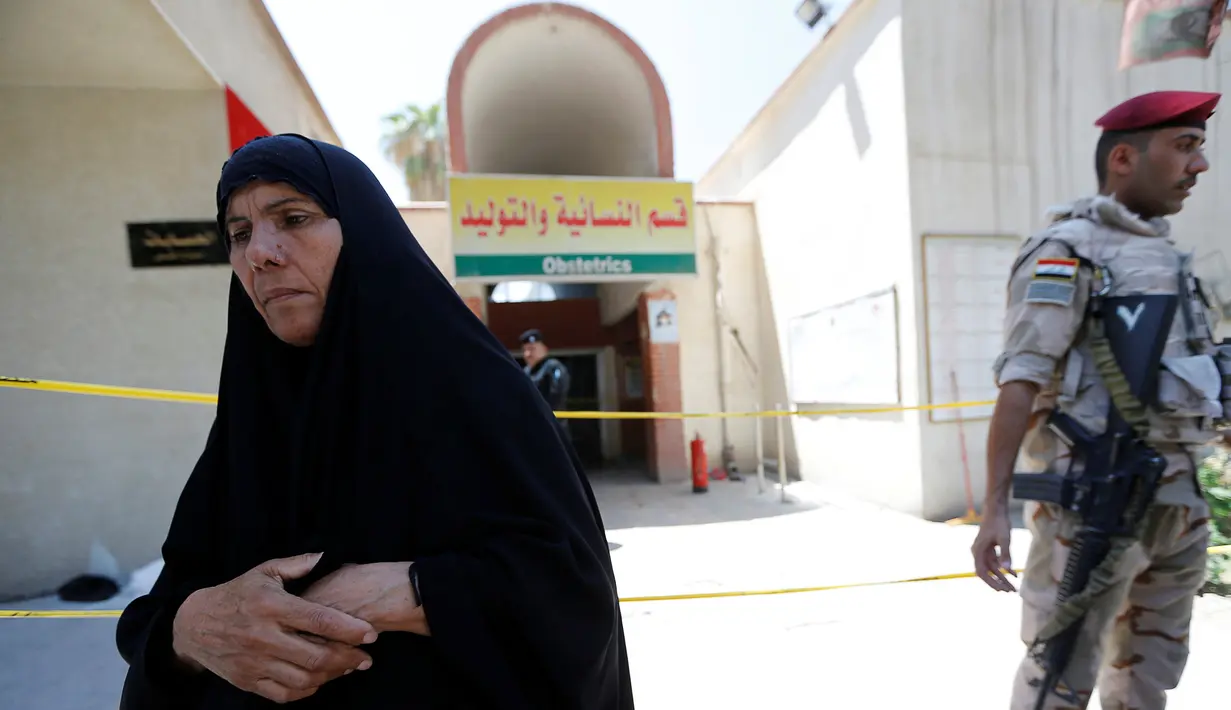 Seorang wanita Irak berdiri di depan bangsal bersalin setelah insiden kebakaran di Rumah Sakit Yarmouk, Baghdad, Rabu (10/8). Kebakaran tersebut menyebabkan 11 bayi prematur yang berada di inkubator tewas. (REUTERS/Thaier Al - Sudani)