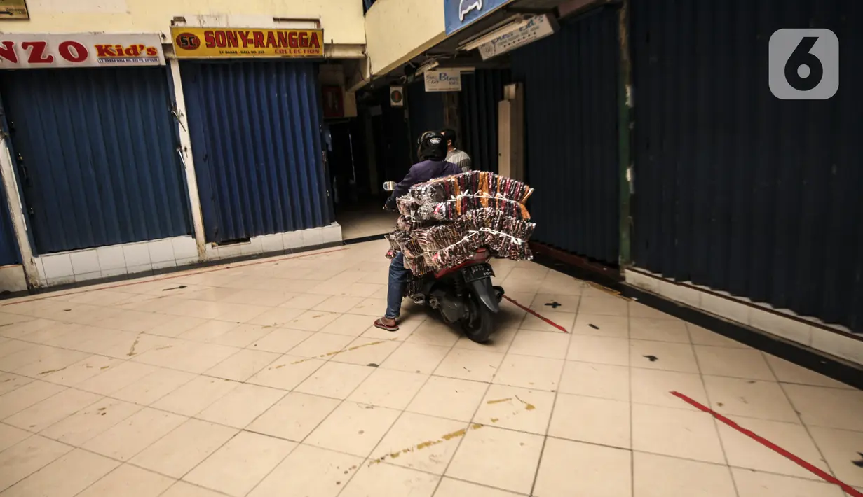 Seorang pengendara motor membawa barang-barang di Pasar Cipulir, Jakarta, Rabu (7/7/2021). Pemberlakuan Pembatasan Kegiatan Masyarakat (PPKM) Darurat pada tanggal 3 sampai 20 Juli 2021 untuk menekan penyebaran COVID-19 berdampak pada ditutupnya Pasar Cipulir. (Liputan6.com/Johan Tallo)