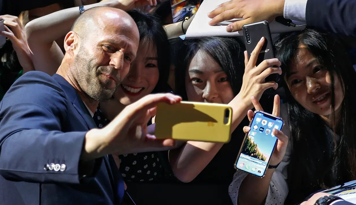 Aktor Jason Statham berswafoto bersama penggemar selama acara red carpet dalam premiere film 'Fast & Furious: Hobbs & Shaw' di Beijing, China, Senin (5/8/2019). Hobbs and Shaw menempatkan dua aktor laga papan atas, Jason Statham dan Dwayne Johnson sebagai pemeran utama. (AP Photo/Andy Wong)