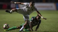 Gelandang Persebaya, Abu Rizal Maulana, menghindari tekel gelandang PSMS, Frets Butuan, pada laga final di Stadion GBLA, Bandung, Selasa (28/11/2017). Persebaya menang 3-2 atas PSMS. (Bola.com/Vitalis Yogi Trisna)