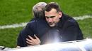 Pelatih Ukraina, Andriy Shevchenko, memeluk pelatih Prancis, Didier Deschamps, pada laga Kualifikasi Piala Dunia di Stadion Saint Denis, Paris, Kamis (25/3/2021). Kedua tim bermain imbang 1-1. (AFP/Anne-Christine Poujoulat)