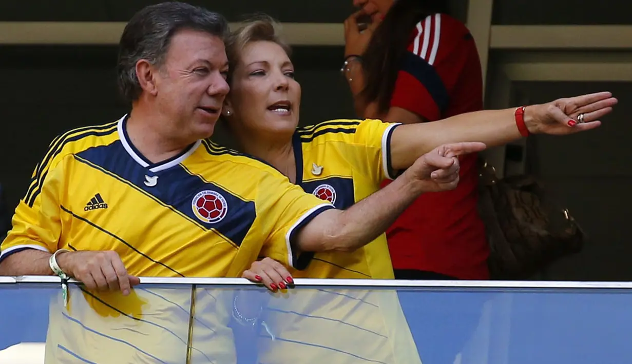 Bersama sang istri, Maria Clemencia (kanan), Presiden Kolombia Juan Manuel Santos, berada di tribun kehormatan Stadion National Mane Garrincha, Brasil, (19/6/2014), menyaksikan langsung James Rodriguez dkk melawan Pantai Gading. (REUTERS/Paul Hanna)