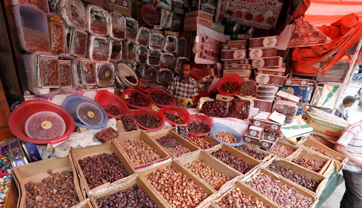 Pedagang kurma menunggu pembeli selama bulan suci Ramadan di sebuah pasar di ibukota Sanaa, Yaman (22/5). (AFP Photo/Mohammed Huwais)