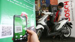 Konsumen memindai barcode untuk dapat berpartisipasi dalam kampanye Bosch di salah satu bengkel di Jakarta, Jumat (22/4/2022). Bosch melalui Divisi Automotive Aftermarket menggagas Kampanye Silaturahmi Aman dan Nyaman sebagai bentuk ajakan kepada masyarakat untuk melakukan pengecekan sepeda motor, terutama pada sistem kelistrikannya. (Liputan6.com/Fery Pradolo)