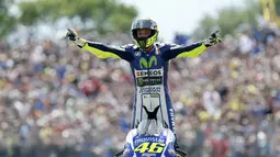 Pembalap tim Movistar Yamaha MotoGP Valentino Rossi merayakan kemenangannya setelah memenangkan Grand Prix di Sirkuit TT di Assen pada 27 Juni 2015. Keputusan Rossi untuk pensiun diumumkan dalam jumpa pers jelang balapan di Austria, Kamis (5/8/2021) malam WIB. (AFP/Bas Czerwinski/ANP)