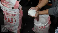 Petugas memperlihatkan gula pasir yang berhasil diamankan, Jakarta, Rabu (24/6/2015). Sebanyak 60 ton gula pasir dan tiga orang tersangka berhasil diamankan Polda Metro Jaya di kawasan Tangerang. (Liputan6.com/Johan Tallo)