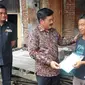 Didampingi Bupati Gowa Adnan Purichta, Menteri ATR/Kepala BPN Hadi Tjahjanto bagikan sertifikat PTSL (Liputan6.com/Ahmad Yusran)