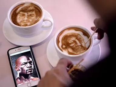 Seniman grafis yang berprofesi sebagai barista, Zach Yonzon melukis wajah petinju Floyd Mayweather asal Amerika Serikat dan Manny Pacquiao (Filipina) pada busa kopi susu latte di sebuah kafe di Manila, Filipina, Kamis (23/4/2015). (AFP PHOTO/Noel Celis)